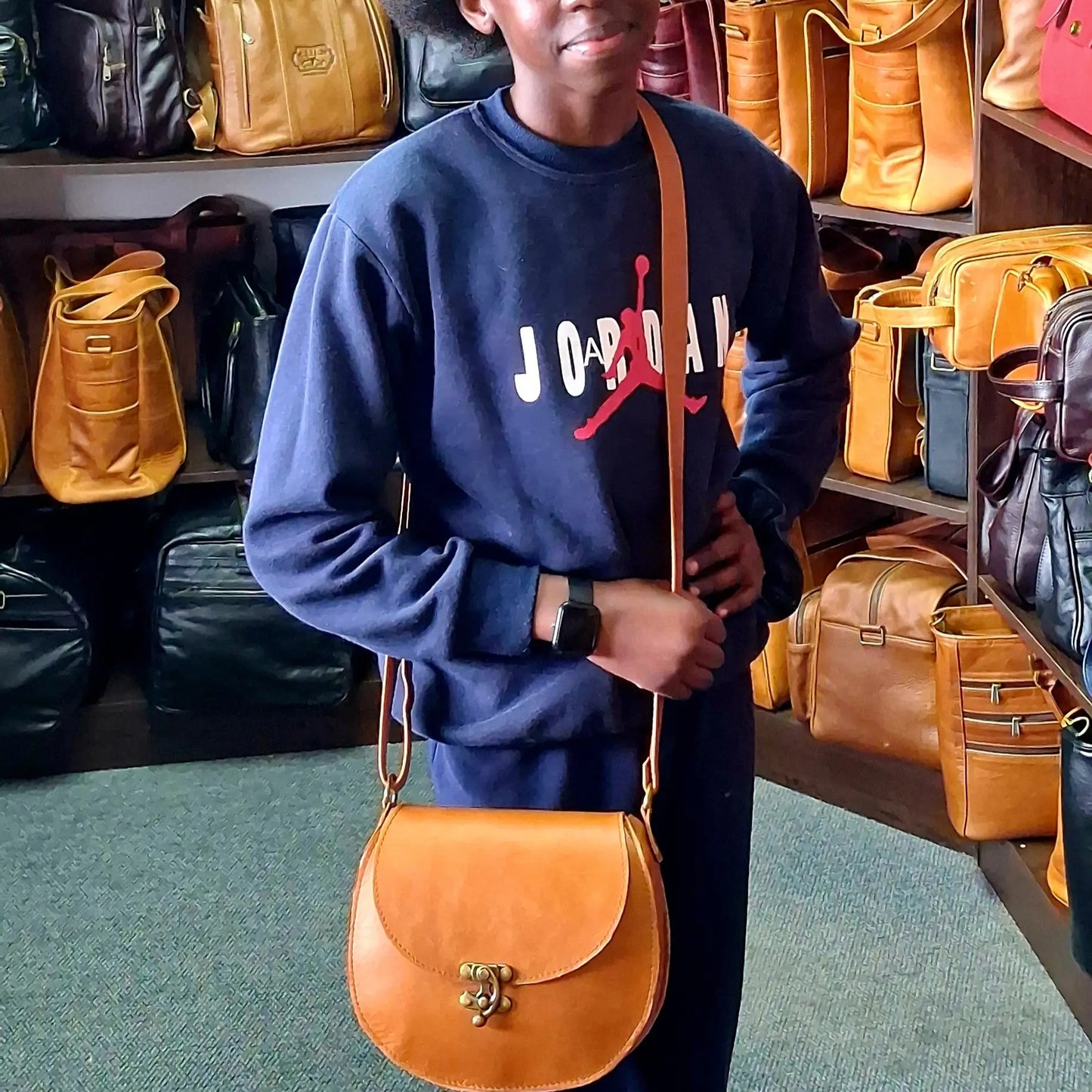 A girl wearing blue Jordan carrying D Bag big leather bags / Mini Sandle bag in light tan made by Cape Masai leather in Cape Town