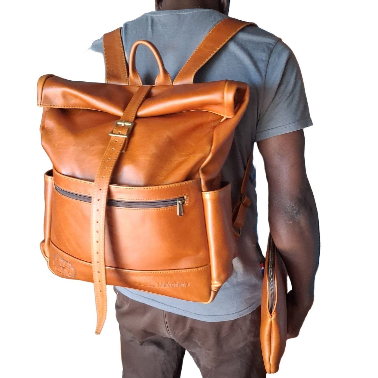 A man carrying Barutile Leather Backpacks toffee tan colour on his back.
