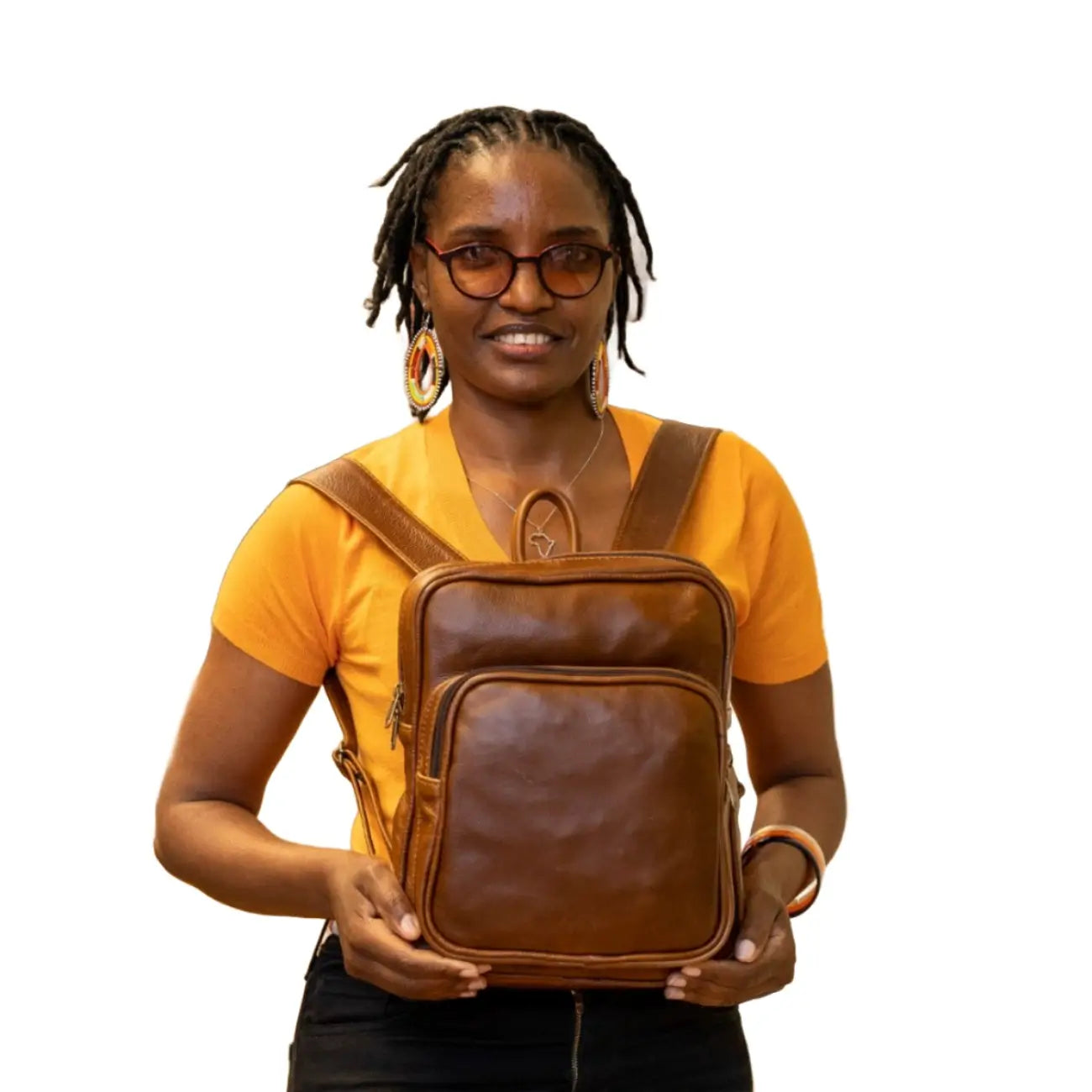 A beautiful Masai lady carrying beautiful pecan tan a small Everyday leather backpack for women from Cape Masai Leather .