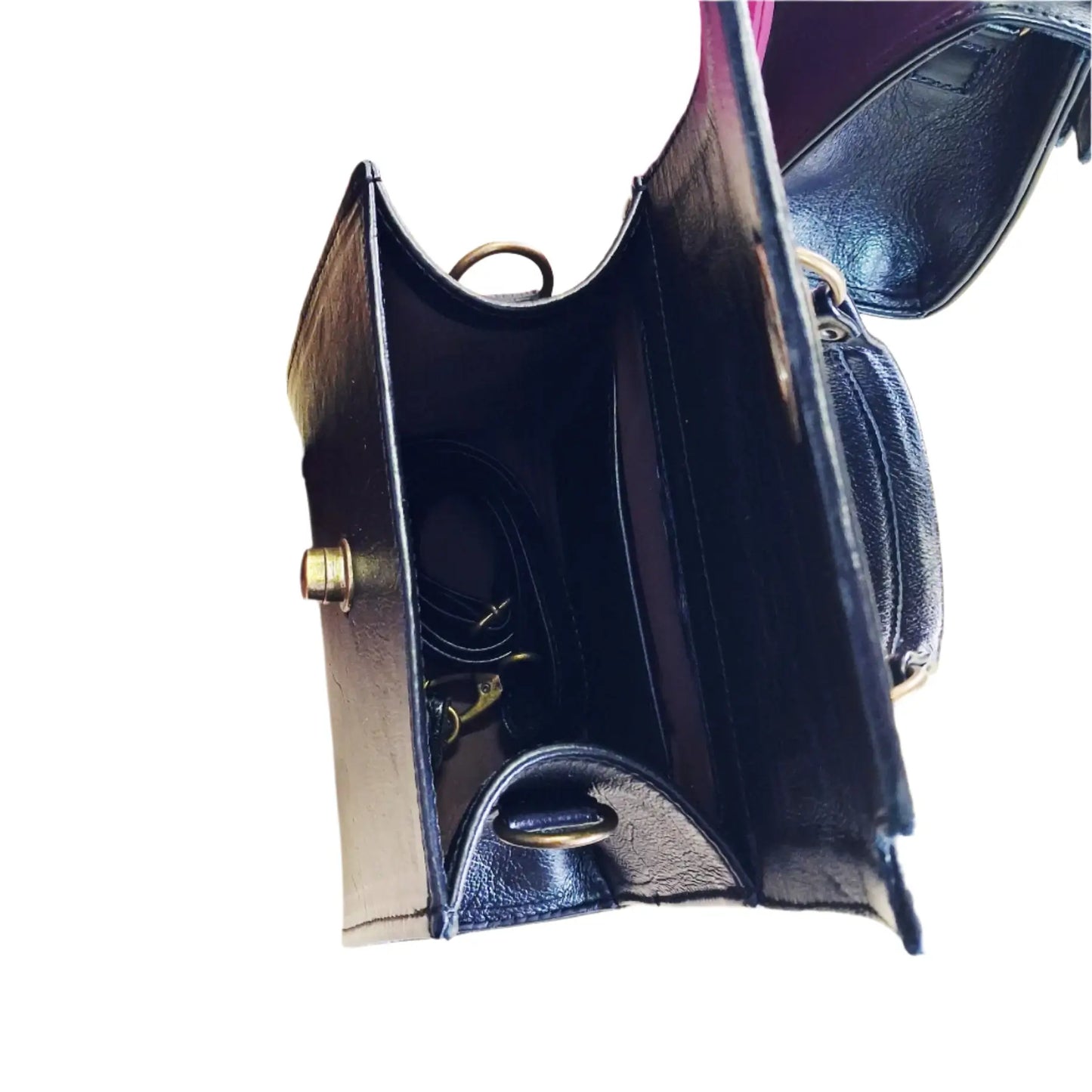 Close-up of a Lawrene designer handbag with ant brass hardware on a white background