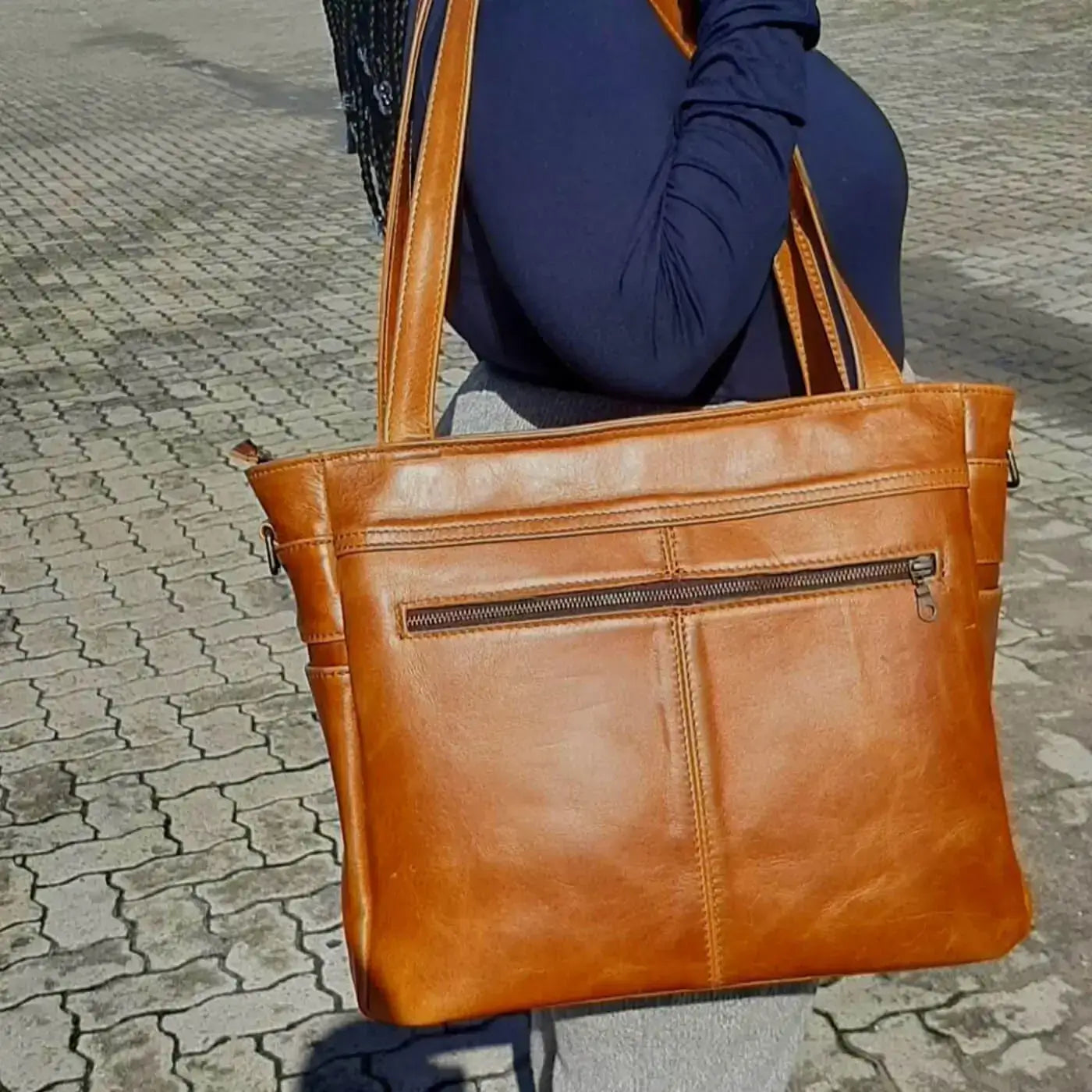 A beautiful African lady with a Marie Nel leather bags light tan colour outside Cape Masai Leather shop