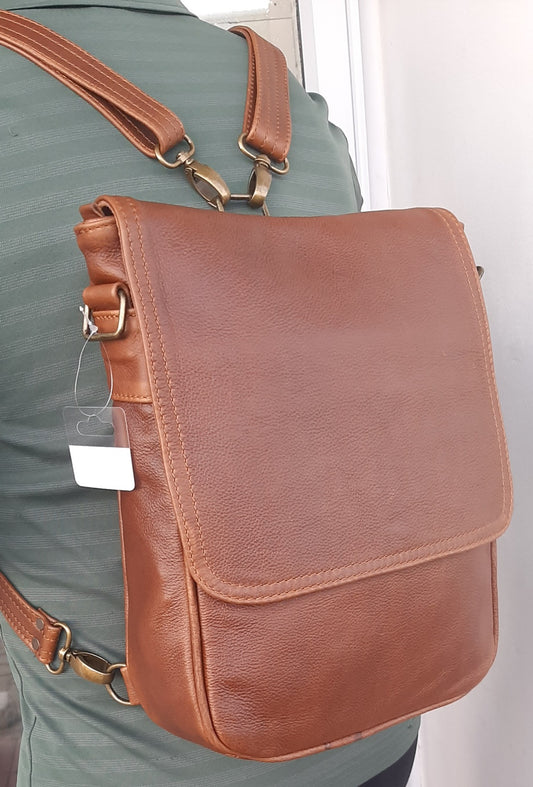 A man carrying a beautiful genuine leather hand made 2 in 1 Am messenger backpack in pecan tan