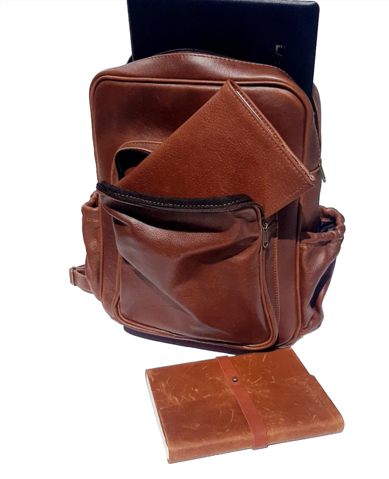 A laptop in Everyday Laptop backpacks 15 inche with a leather diary in the front  pocket  and  next to A5 executive book covers on the floor.