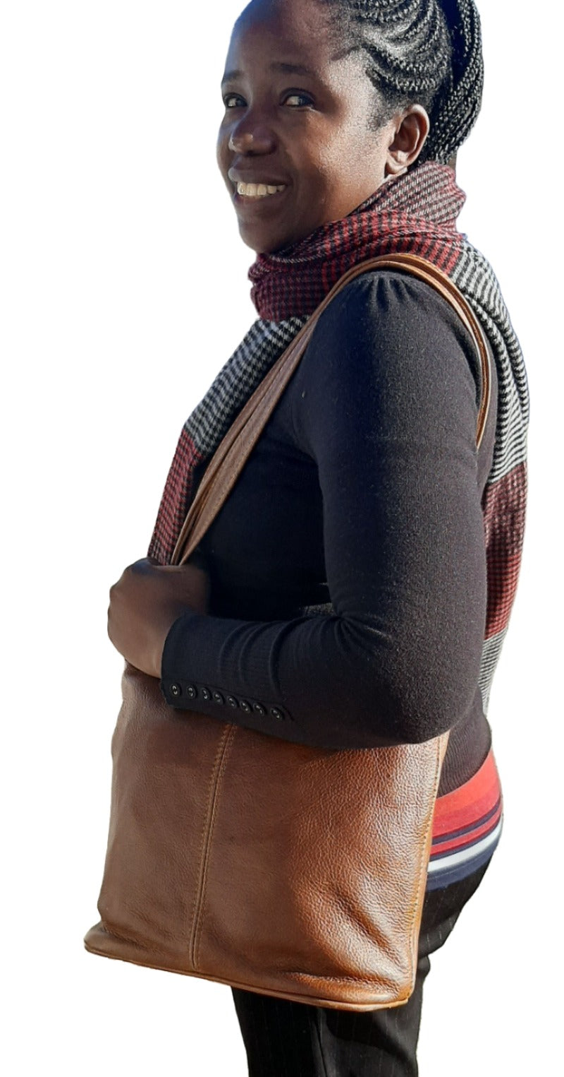 A lady carrying beautiful pecan tan Cm small leather bags from Cape Masai Leather