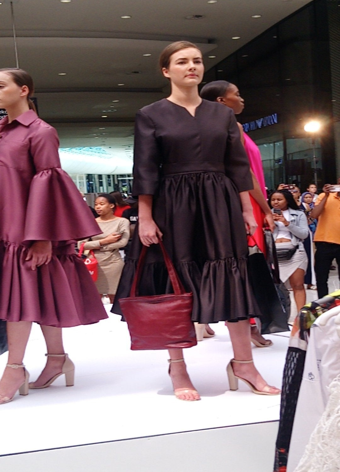 A lady carrying beautiful a cherry red Cm small leather bags from Cape Masai Leather