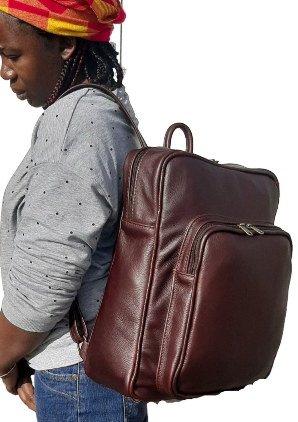 A beautiful African lady carrying a beautiful genuine leather backpack in dard tan from Cape Masai Leather.