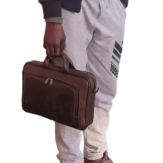 A boy carrying a genuine leather A4 laptop bags 12 inche  - Diesel Pitstop Rust  outside Cape Masai Leather shop