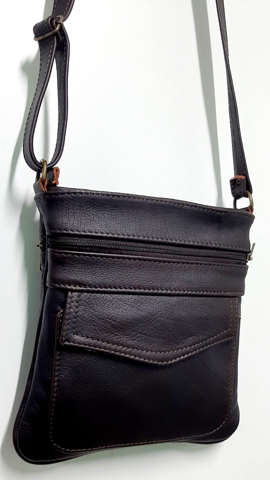 A beautiful genuine leather Leony sling bag hanging at Cape Masai leather factory shop