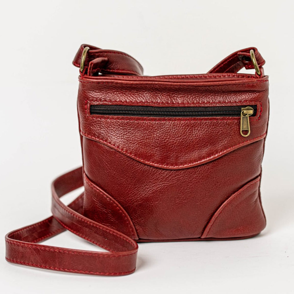 sling bag short in cherry red standing on the floor