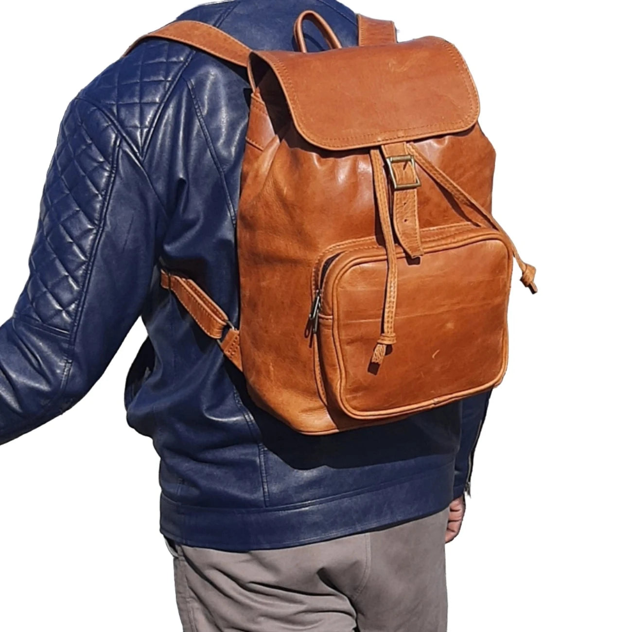 A gentle man carry toffe tan  leather backpack with flap xl without side pockets on his back outside Cape Masai Leather