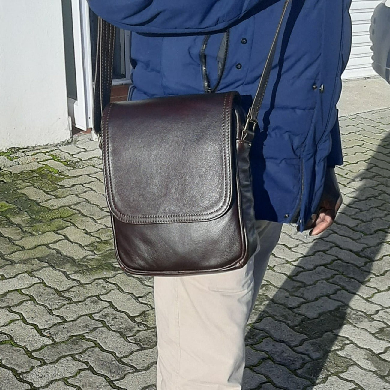 A man caring messenger bag with flap made by cape Masai Leather