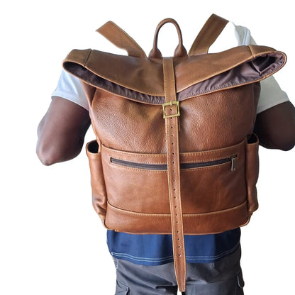 A man carrying Barutile Leather Backpacks pecan tan colour on the back