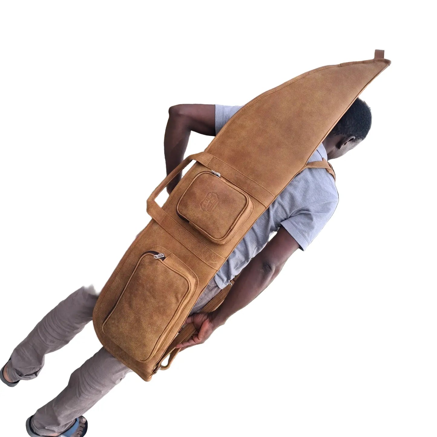 A man carrying on his back Cape Masai Leather rifle bag / guitar case in bitter brow on a white background