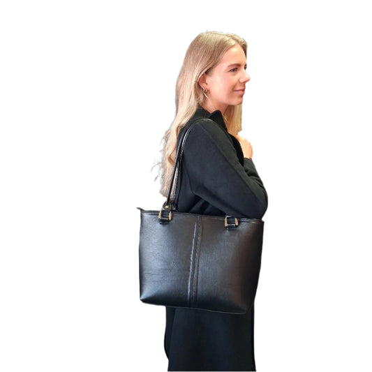 Woman carrying a black Michelle leather tote bag on a white background made by Cape Masai Leather.