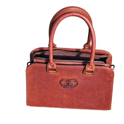 Cape designer bag small in pitstop cigar handbag with double top handles and a shoulder strap, 
The bag has an embossed logo patch on the front.