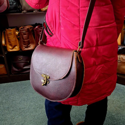 Person wearing a red jacket holding a dark tan D Bag big leather bags