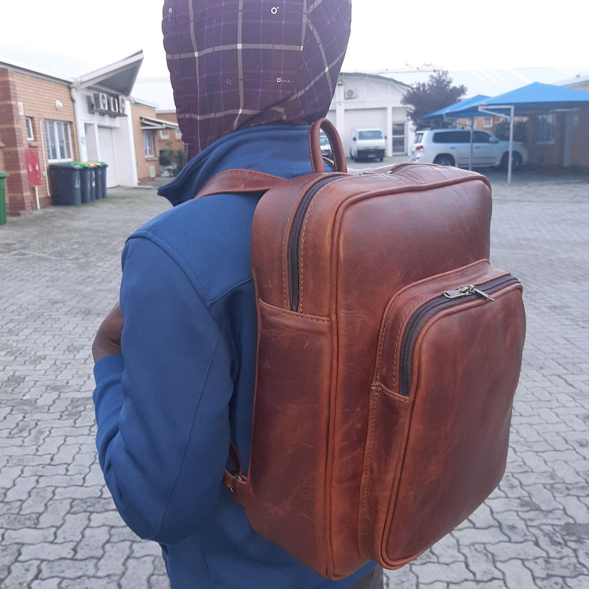A boy carrying geniune leather  Everyday Laptop Backpacks 15" in pitstop cigar colour from Cape Masai Leather 