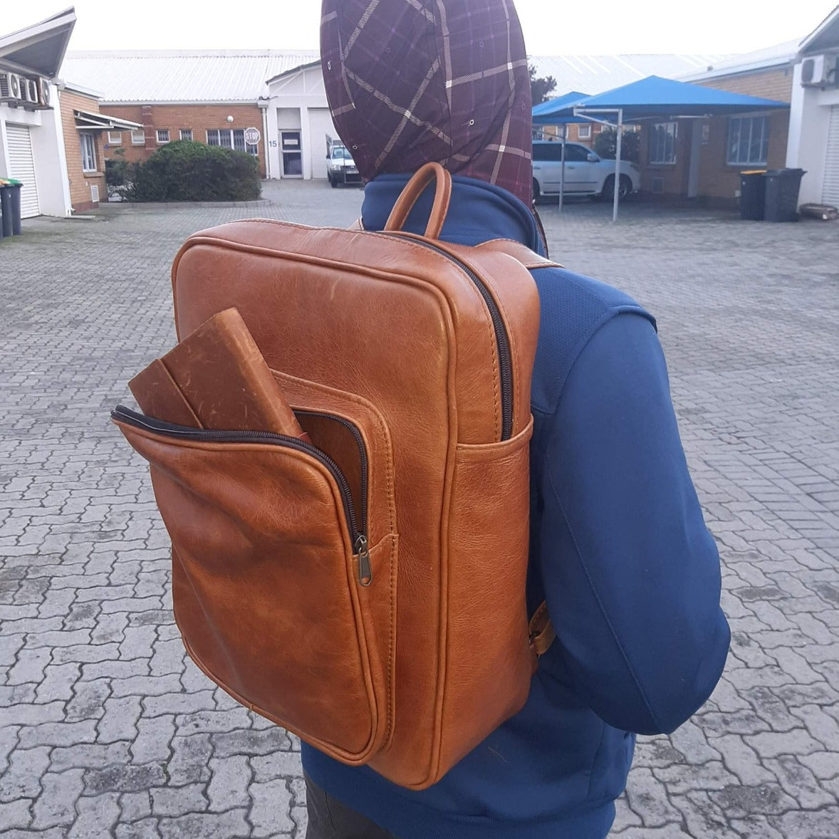 A boy carrying Everyday Laptop Backpacks 15" in light tan colour from Cape Masai Leather 