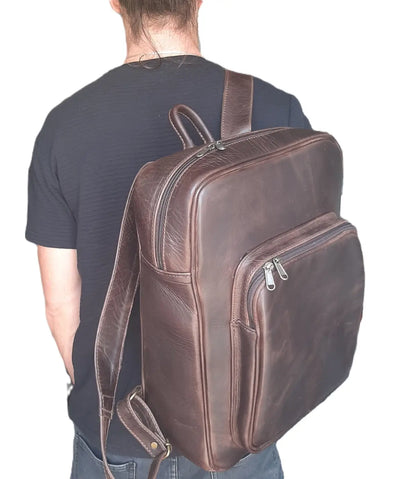 A man carrying genuine leather Everyday Laptop Backpacks 15" with side pockets in diesel brown colour from Cape Masai Leather