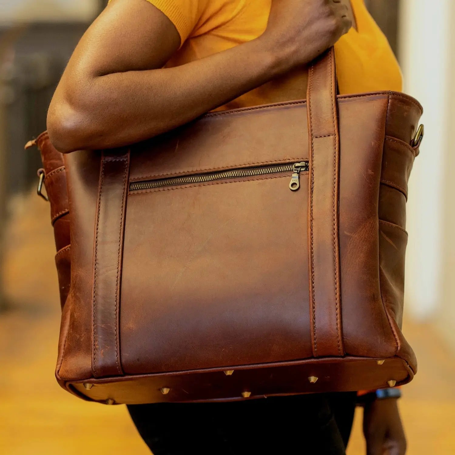 A lady in yellow carrying Ladies Laptop bags in Diesel Pitstop cigar colour made in Cape Town by Cape Masai leather