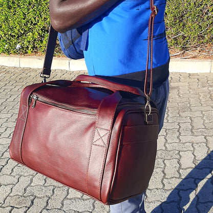 A man carrying Masai leather Gym bag in darktan