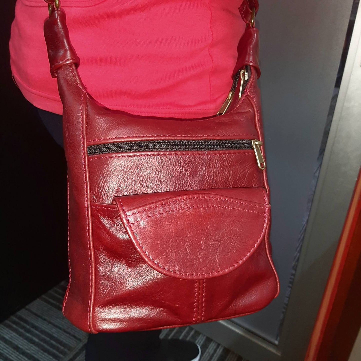 A lady carrying SH small leather bags in Cherry red colour at Cpe Masai  Leather  