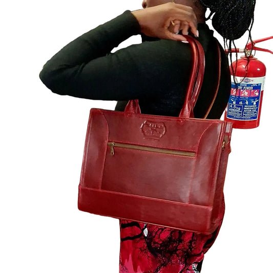 Woman holding Kirstein 14 inches laptop bag in cherry red colour from Cape Masai Leather. 