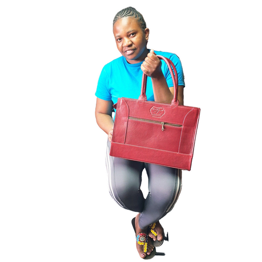 Woman holding Kirstein 14 inches laptop bag in cherry red colour from Cape Masai Leather. 