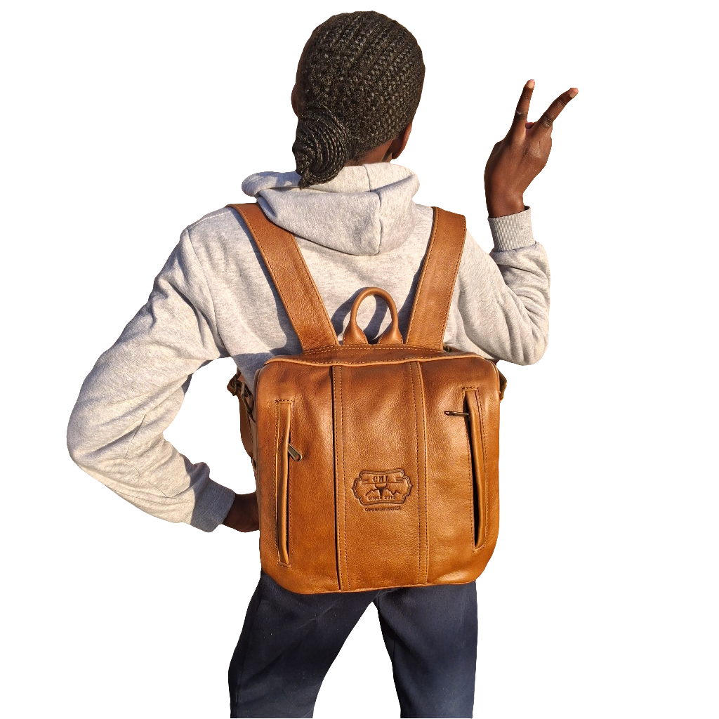 A girl carrying Helmare leather Backpacks by cape Masai Leather in Pecan tan colour on her back.