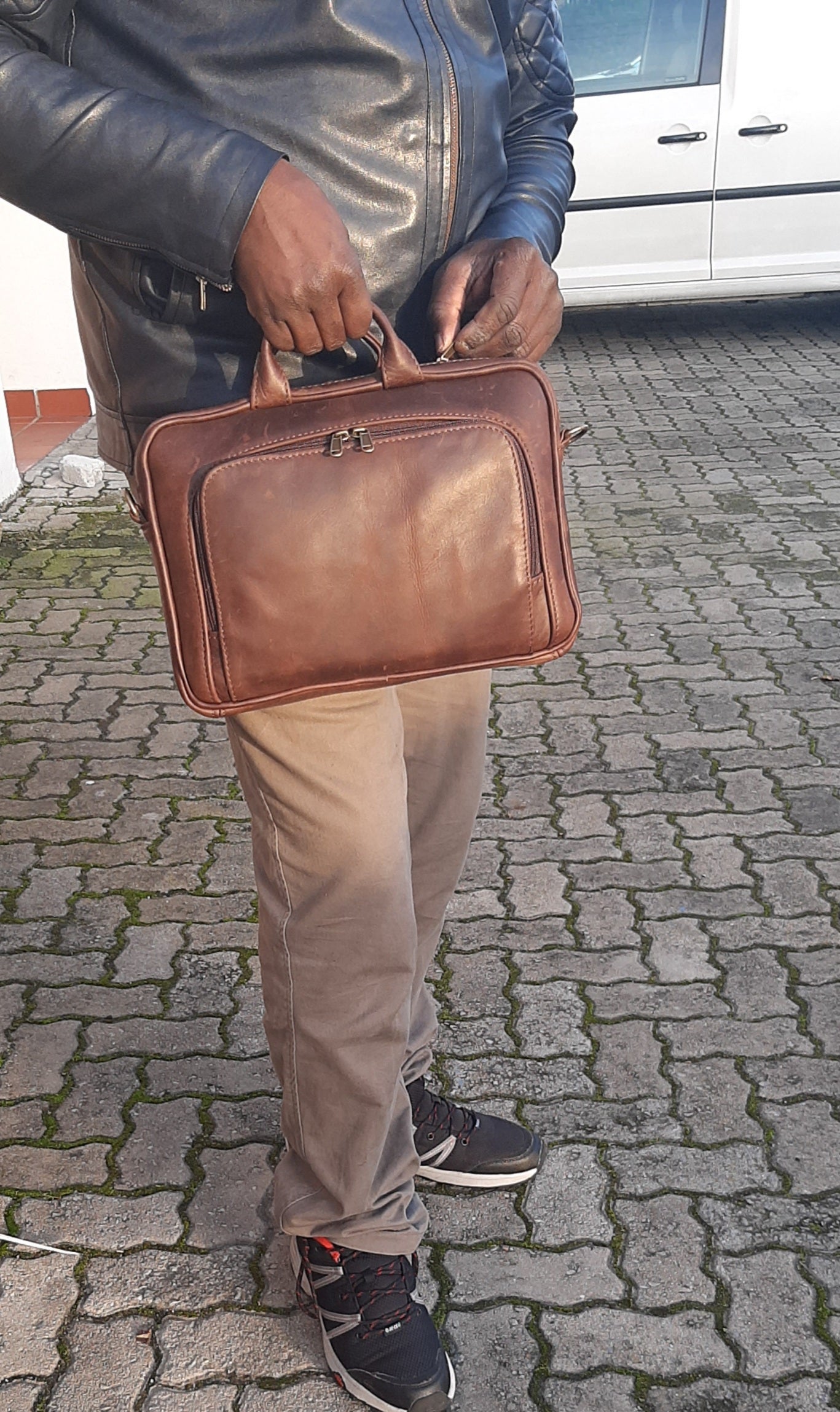A man opening his genuine leather A4 laptop bags 12 inche laptop bag - Diesel Pitstop Rust  outside Cape Masai Leather shop