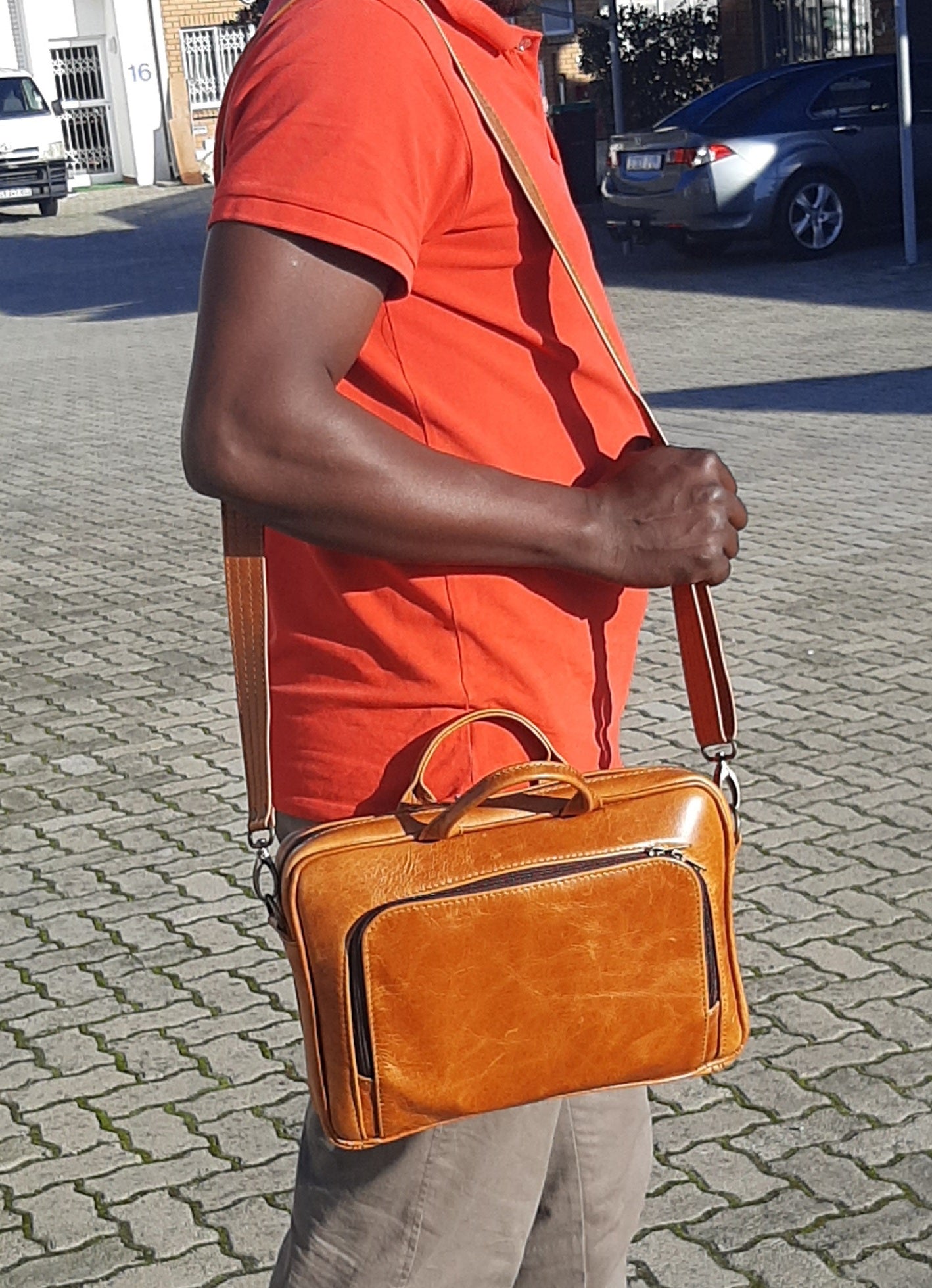 A man carrying beautiful A4 laptop bags 12 inche outside Cape Masai Leather shop