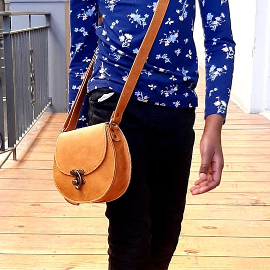 A  lady carrying a beautiful crossbody D Bag small leather bags from Cape Masai leather  in Cape Town 