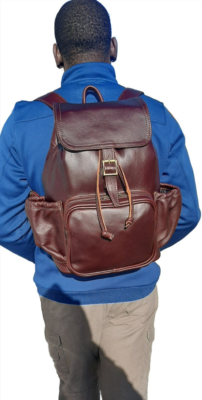 A man carrying  leather backpack with flap xl in dark tan colour on his back from Cape Masai Leath