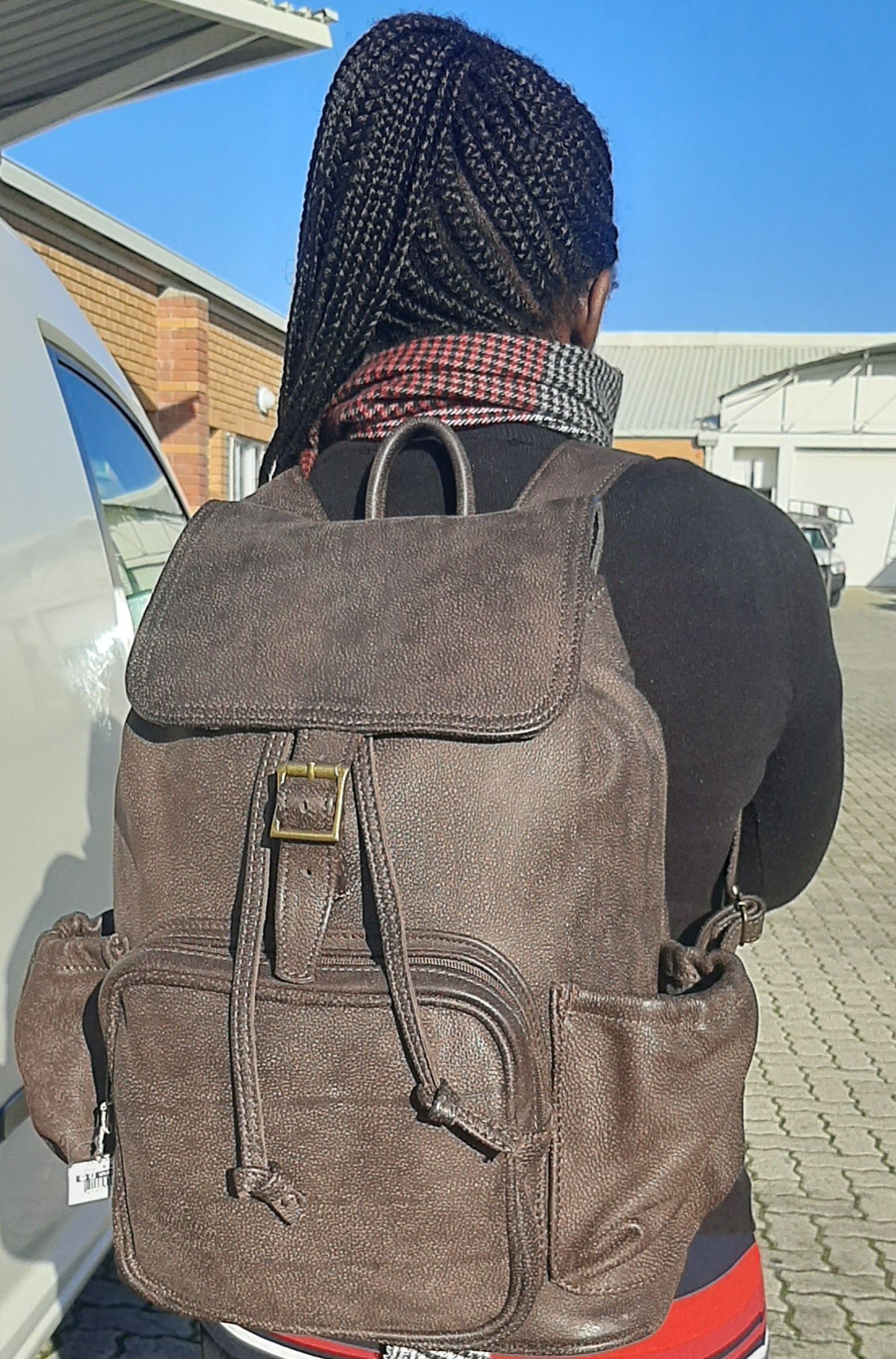 A lady carrying beautiful Woodlands buffalo  leather backpack with flap xl on her back from Cape Masai Leather