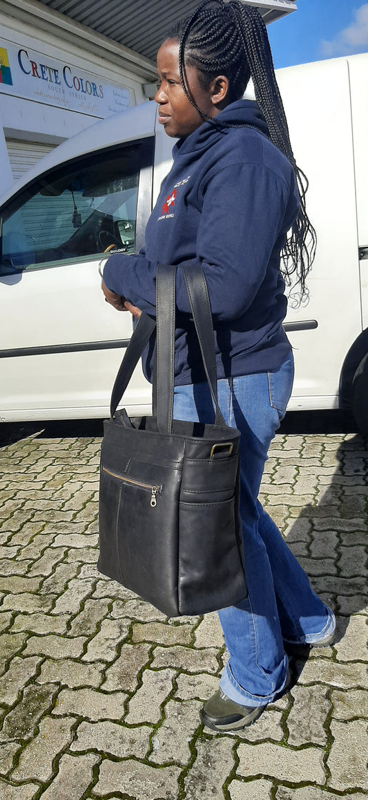 A beautiful African lady with a Marie Nel leather bags  - Diesel black colour outside Cape Masai Leather shop