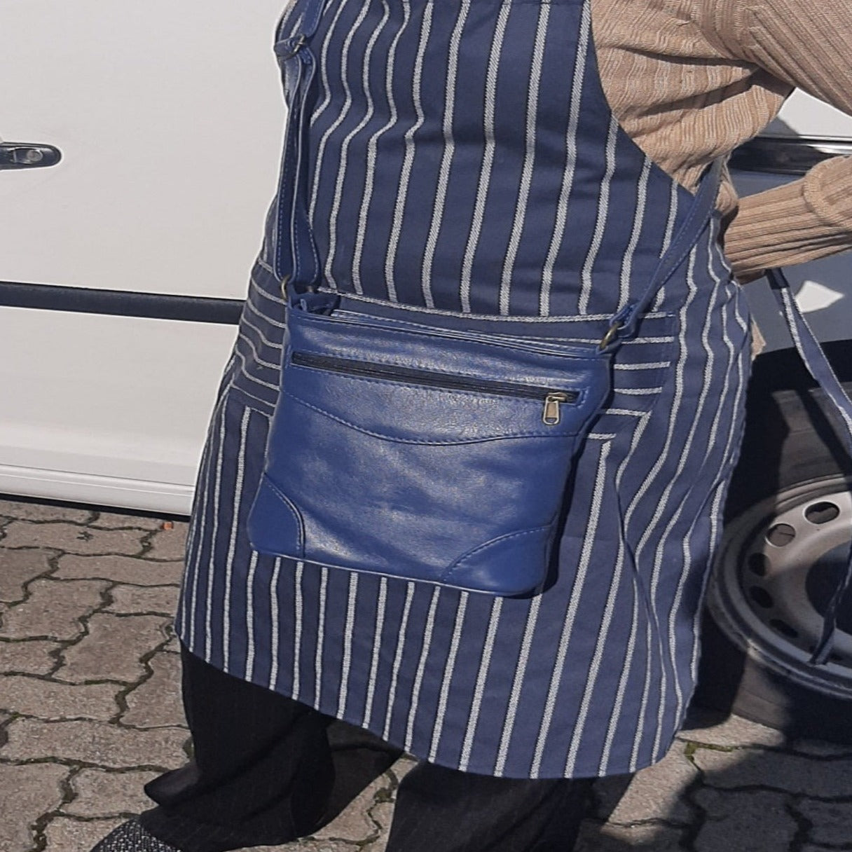 A lady carring sling bag short navy bleu colour made Cape Masai leather  