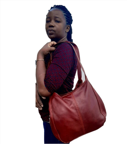 A lady carrying beautiful cherry red/dark red corra leather bag from Cape Masai Leather.