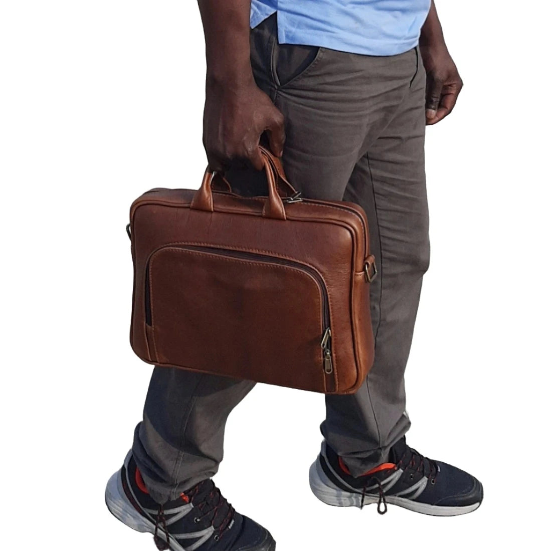 A gentleman walking and carrying Cape Masai leather iconic 14 inches laptop briefcase in pecan tan  colour 